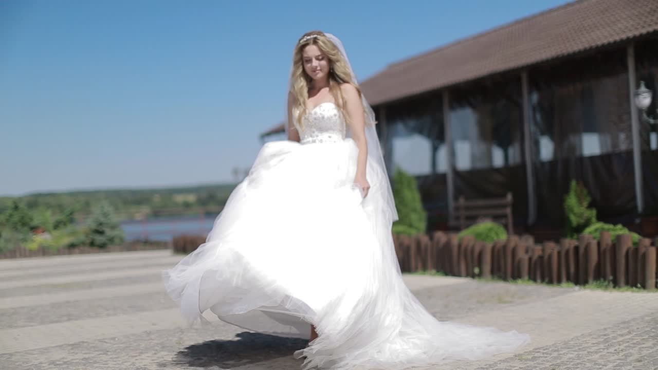 Beauty Bride In Sunny Summer Day. Gorgeous bride with smiles while posing outdoors