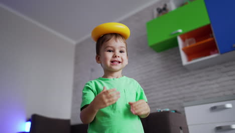 smiling little boy playing in his room. playful kid having fun with toys. low angle view.