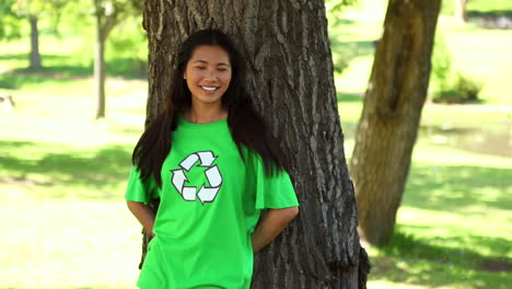 happy environmental activist leaning against a tree