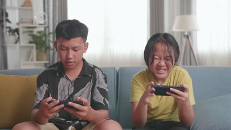siblings playing games on smartphones