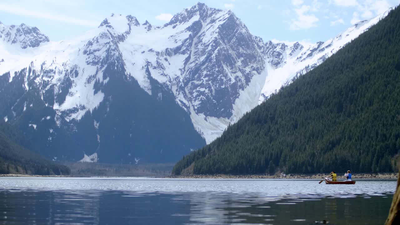 Couple Canoeing on a Calm Lake with Mountain Views