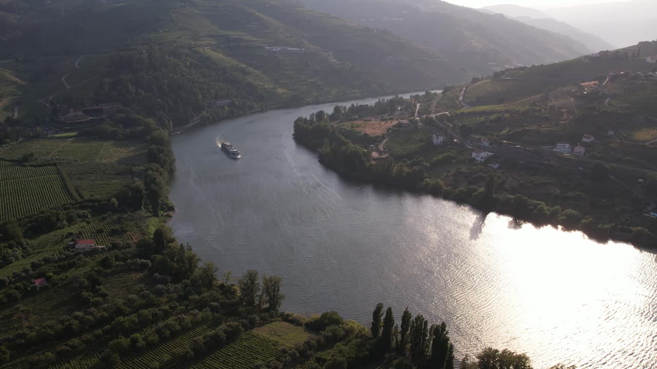 Aerial - Douro River Portugal flowing between green vineyards and mountains at sunset