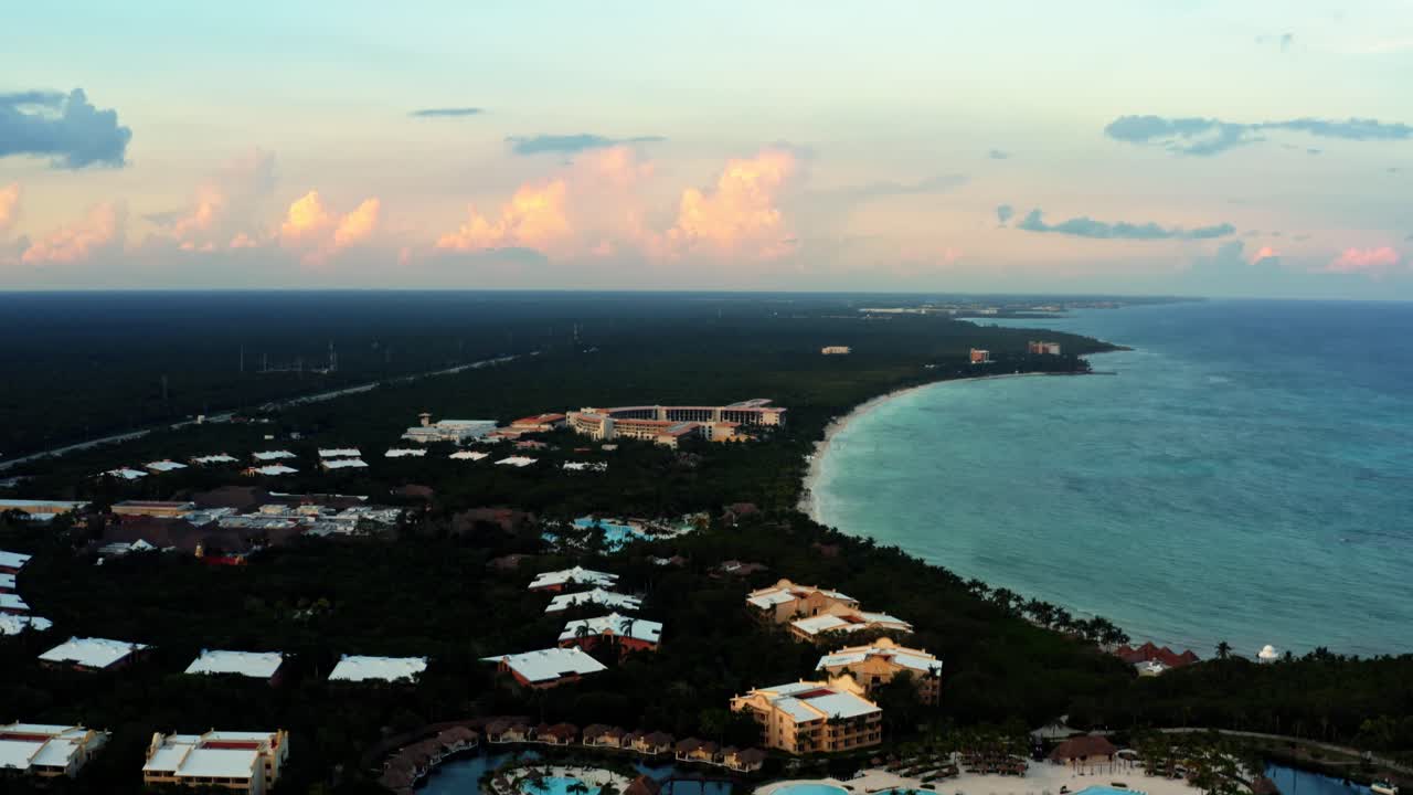impresionante toma aérea de drones inclinados hacia arriba de una línea costera mexicana tropical llena de resorts de vacaciones en la riviera maya entre tulum y cancún durante una cálida puesta de sol de verano