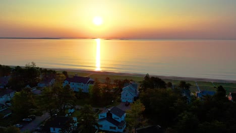 Amanecer-Sobre-Casa-De-Playa-En-Saco-Maine-Con-Colores-Reflejándose-En-Las-Olas-Del-Océano-Y-Casas-De-Vacaciones-A-Lo-Largo-De-La-Costa-Atlántica-De-Nueva-Inglaterra