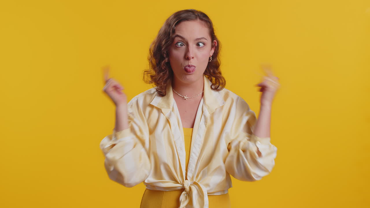 Funny comical woman making silly facial expressions and grimacing fooling around showing tongue