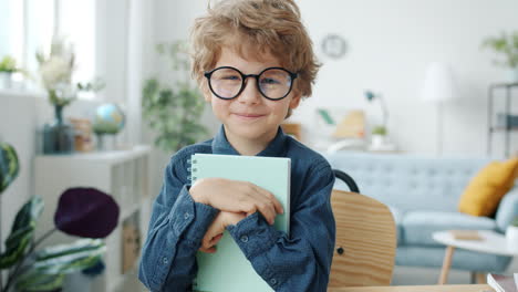 smiling boy with glasses and notebook