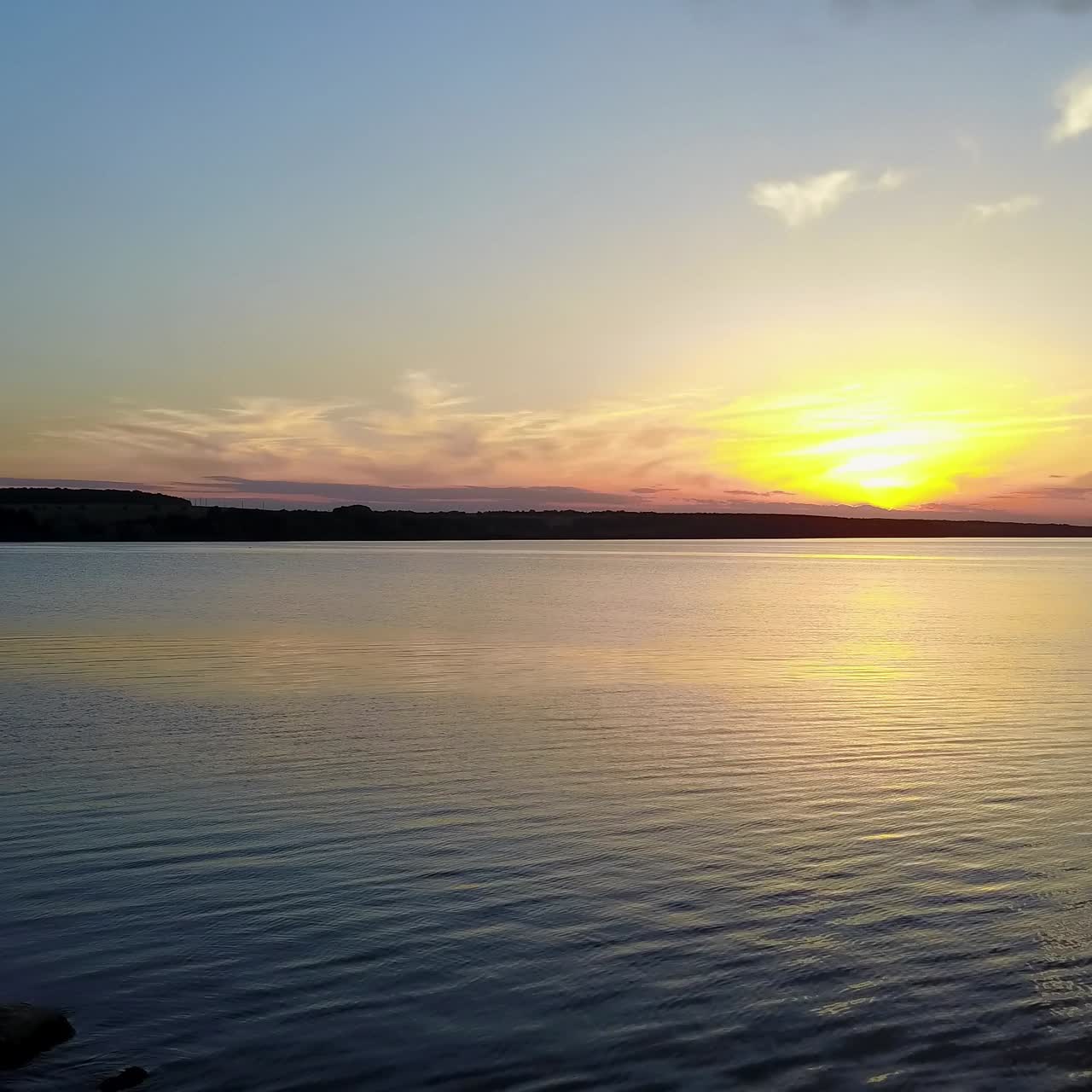 gente disfrutando de la puesta de sol a la orilla del río