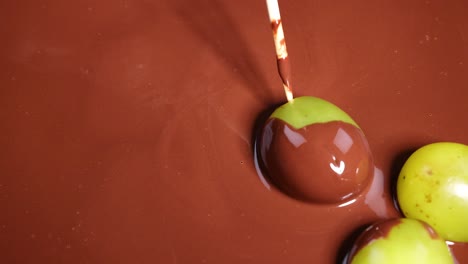 grapes being coated with melted chocolate