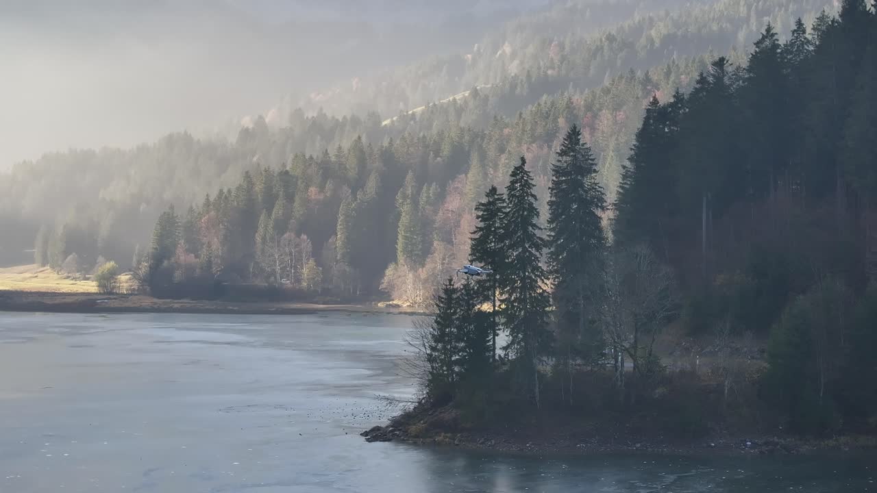 A tranquil aerial view of Lake Obersee near Näfels, Switzerland, with calm waters reflecting the surrounding alpine forests. A serene escape into nature's quiet beauty.