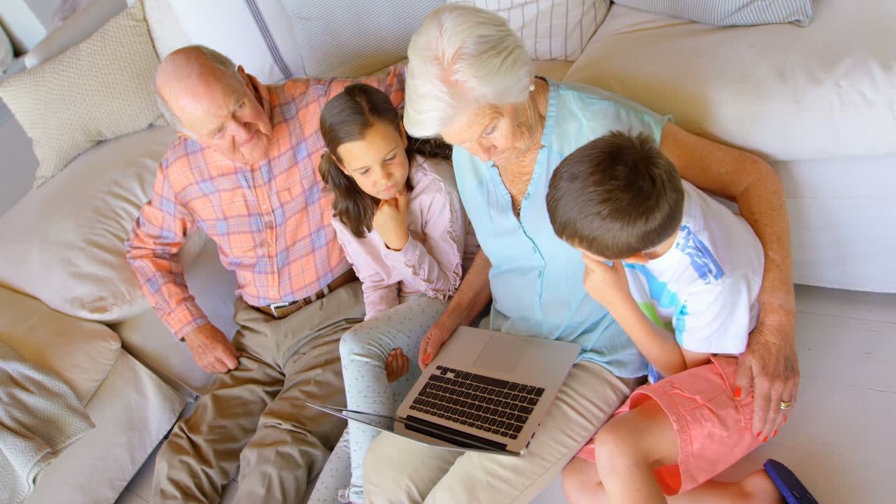High angle view of Caucasian multi-generation family using laptop in a comfortable home 4k