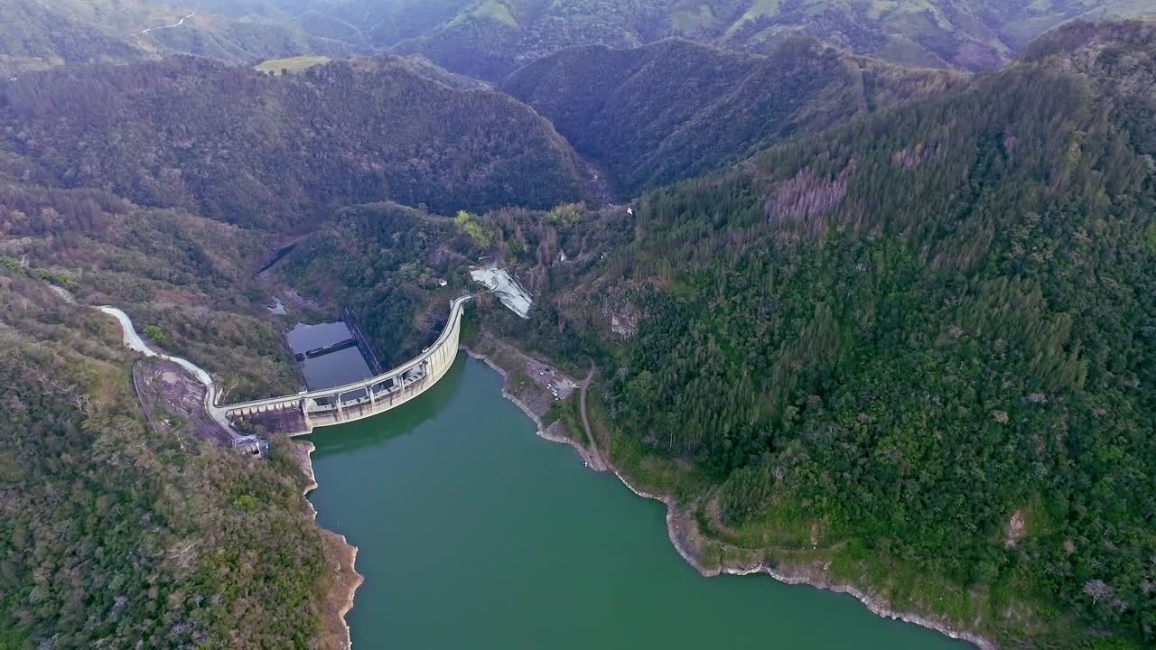 vista aérea sobre la presa de jigüey cerca del río nizao rodeada de verdes montañas en república dominicana