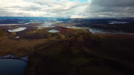 Aerial-landscape-view-of-Icelandic-highlands-with-snow-capped-mountain's-peaks,-rivers-and-lakes