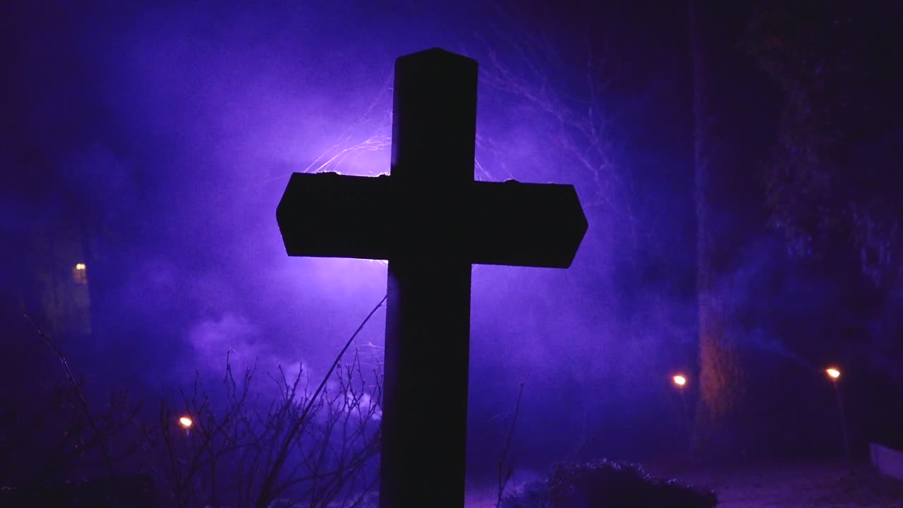A dark cross silhouetted against eerie purple fog, with delicate spider webs visible around the edges, creating a moody, mystical atmosphere