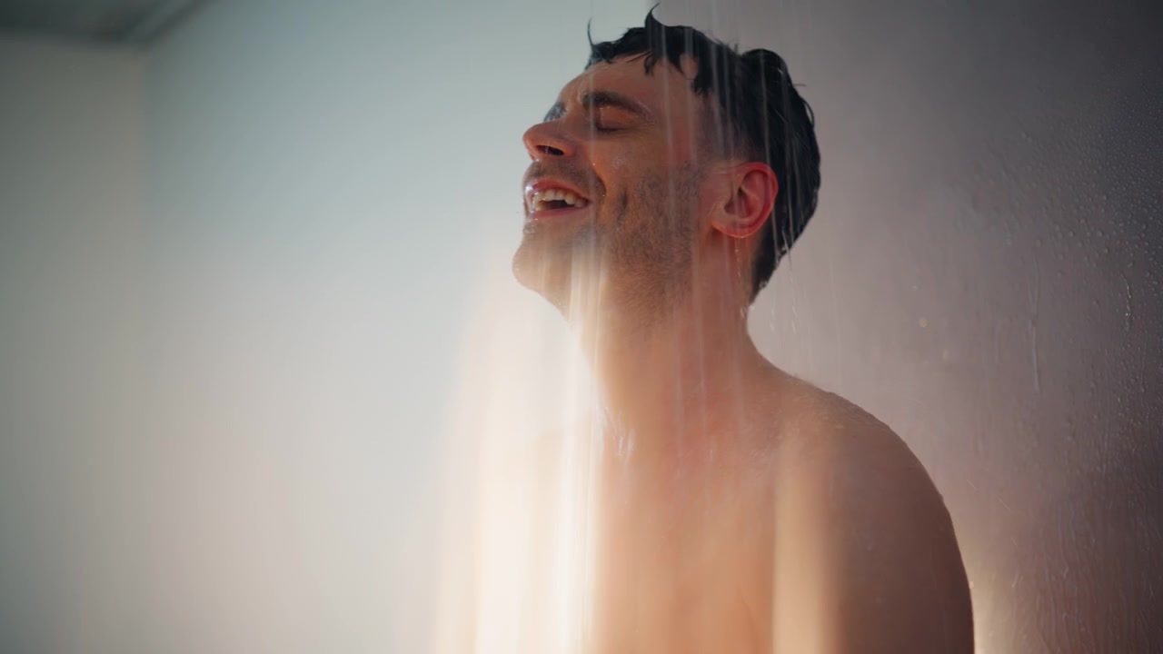 Man washing hair under shower spray. Close up portrait wet male morning bath