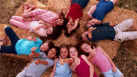 multi ethnic group of children lying in circle on hay