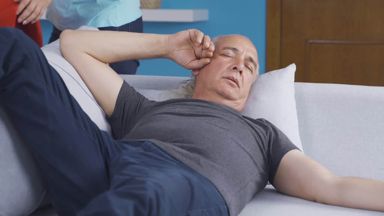 la mujer que cubre a su marido durmiendo. una pareja feliz.