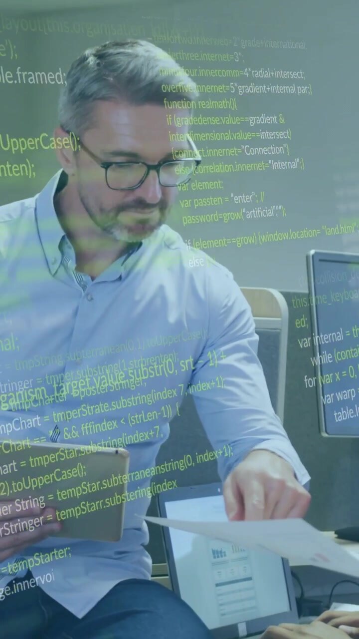 Video vertical: Hombre sentado usando una tablet, recibiendo páginas de un colega, generando una superposición de código para revisión de TI.
