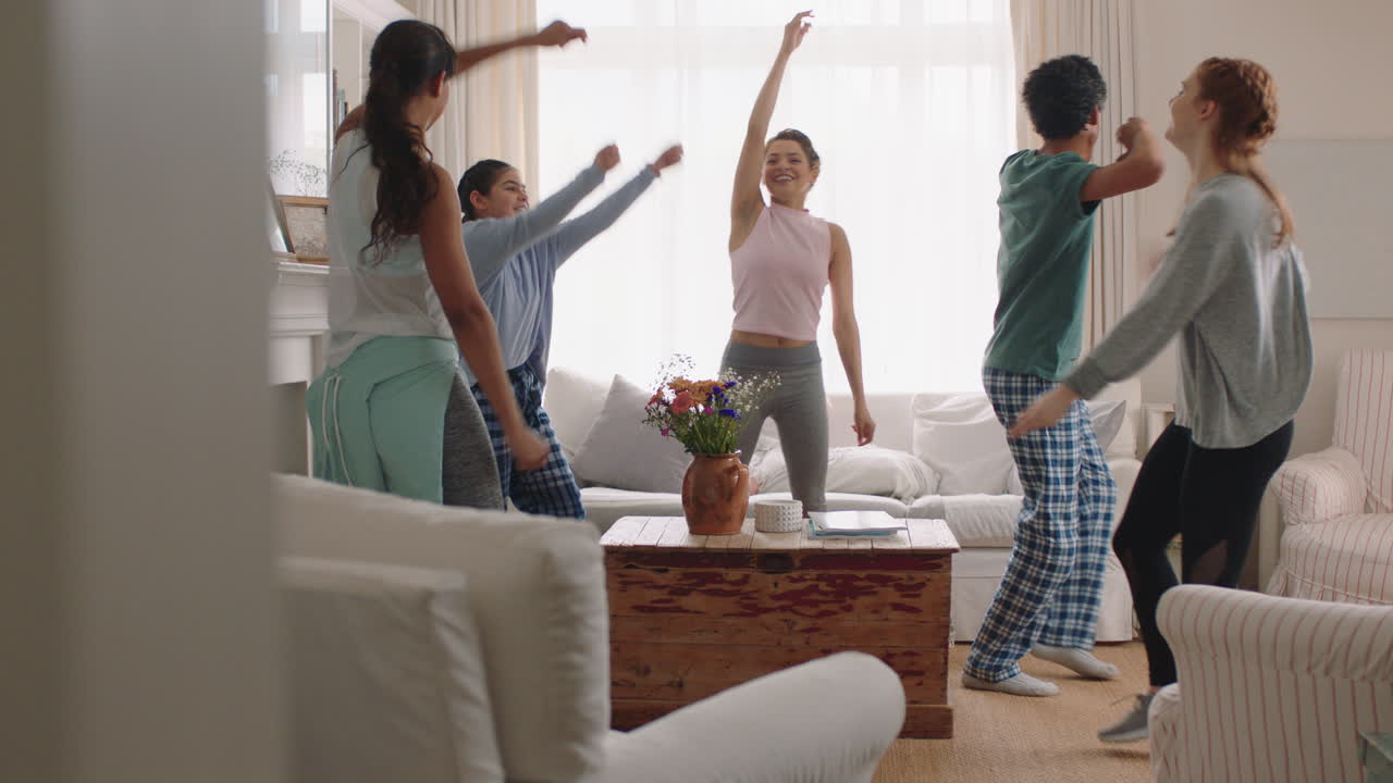 행복한 다민족 가족 집에서 춤을 추고 즐겁게 춤을 즐기고 축하하고 흥미진진한 주말을 함께 파자마를 입고