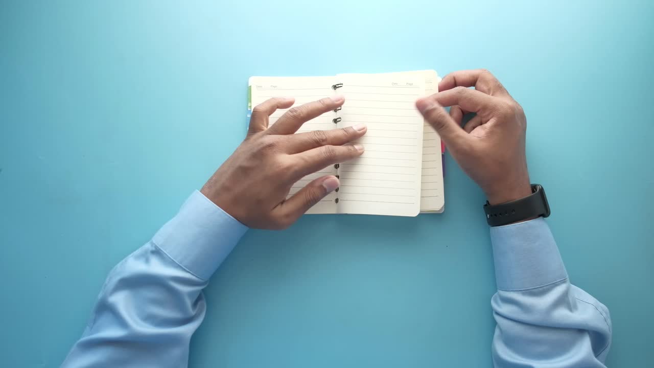 Person holding an open spiral-bound notebook