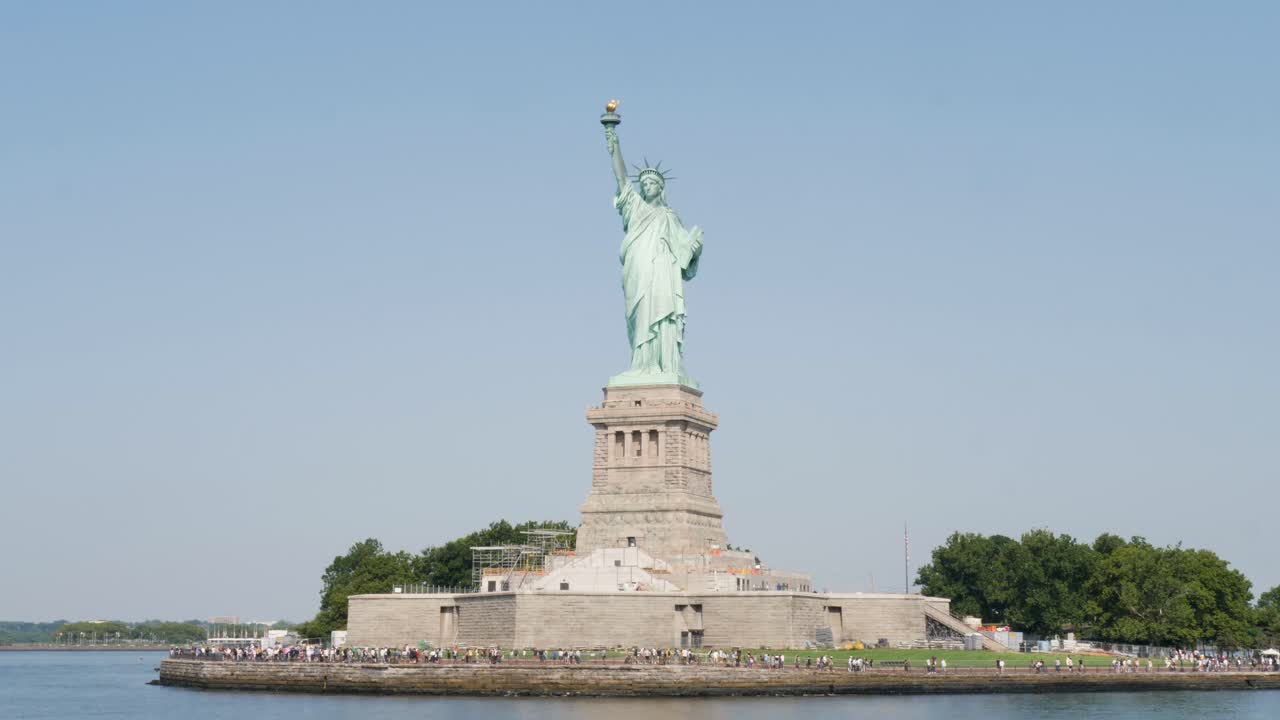 Slow motion landscape of New York city Statue of Liberty holding torch attraction landmark travel Hudson River Manhattan USA America architecture sculpture