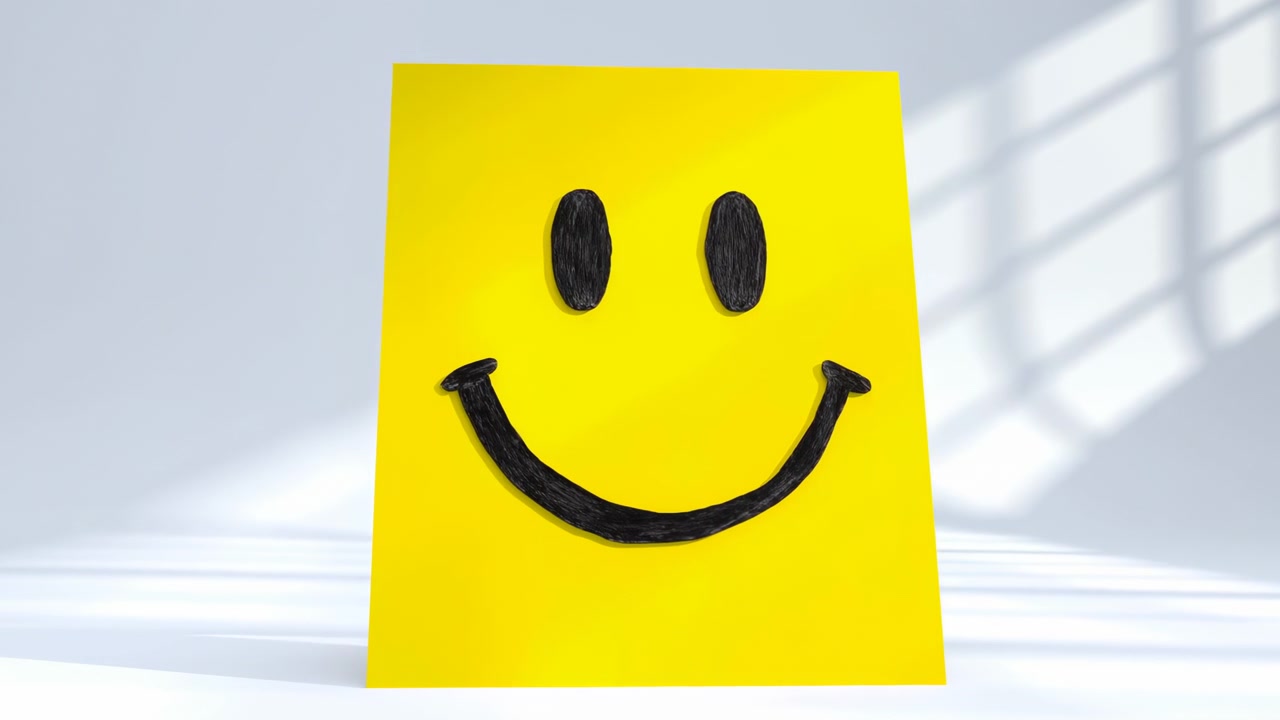 Une carte de note jaune pliée avec un visage souriant dessiné à la main est posée sur une surface blanche et propre, éclairée par une douce lumière du jour avec des ombres de fenêtre dans une pièce intérieure minimaliste