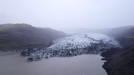 sólheimajökull glacier tongue of ice and ash flowing into a lagoon in iceland