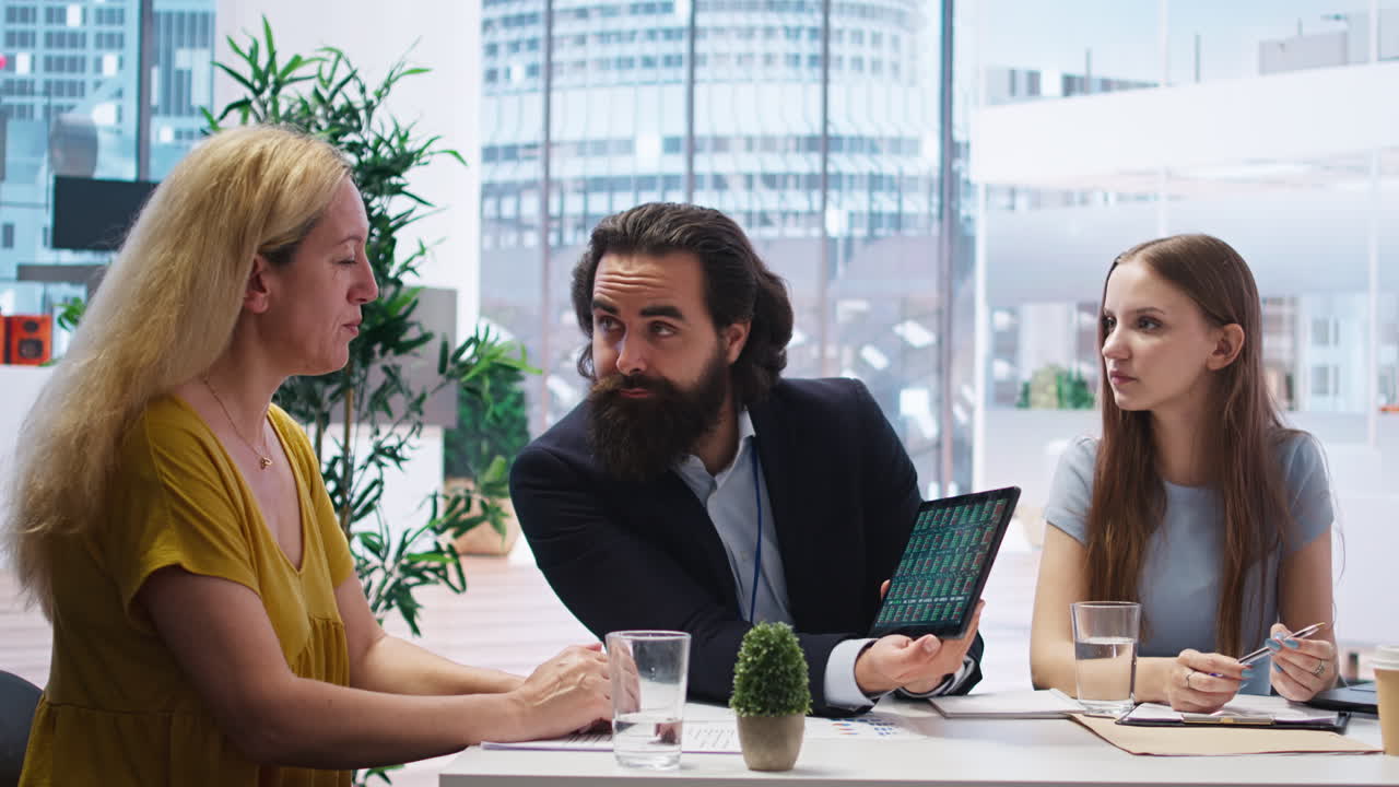 Financial advisor and clients looking at market shares on tablet