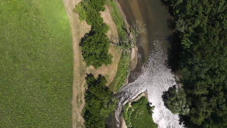 top down view of river flowing through lush forest in oronoco, minnesota, usa - drone shot