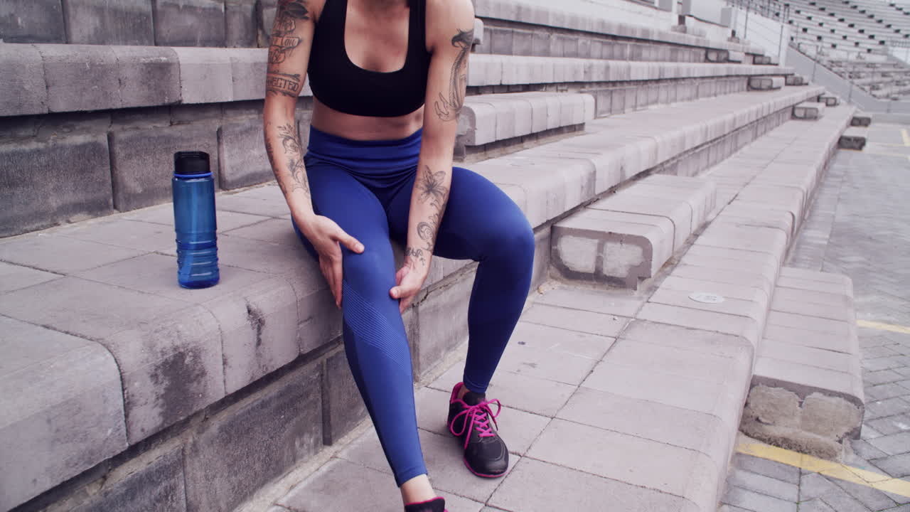 부상당한 운동 선수가 계단에 앉아 있습니다.