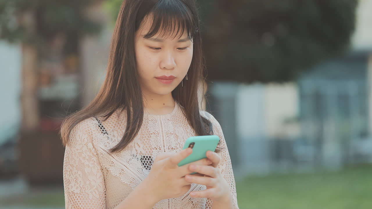 야외에서 스마트폰을 사용하는 여성