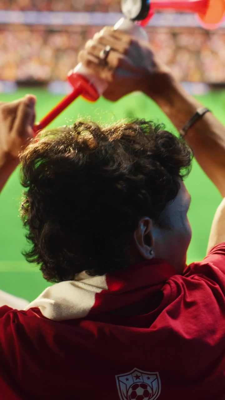 Video verticale Tifosi di calcio con maglie rosse reagiscono con entusiasmo a un gol segnato durante la partita