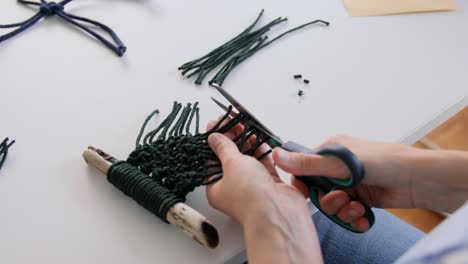 Mujer-Cortando-Cordones-De-Macramé-Con-Tijeras.-Concepto-De-Bricolaje,-Hecho-A-Mano-Y-Pasatiempo.-Mujer-Haciendo-Artesanía-De-Macramé-Y-Cortando-Cordones-Con-Tijeras-En-La-Mesa-En-Casa.