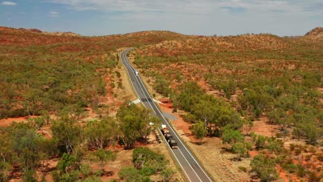 Vista-Aérea-Del-Tren-De-Carretera-De-Tres-Remolques-Que-Viaja-En-La-Carretera-Asfaltada-Del-Interior-En-Qld,-Australia