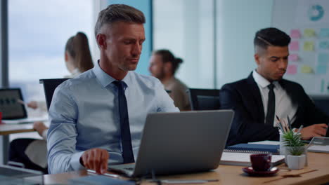 focused businessman working on laptop computer in office