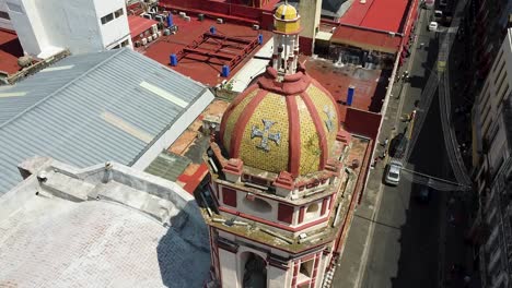 Toma-Aérea-Inclinada-Hacia-Arriba-De-La-Torre-De-La-Iglesia-En-La-Ciudad-De-Puebla-Durante-El-Día-Soleado,-México