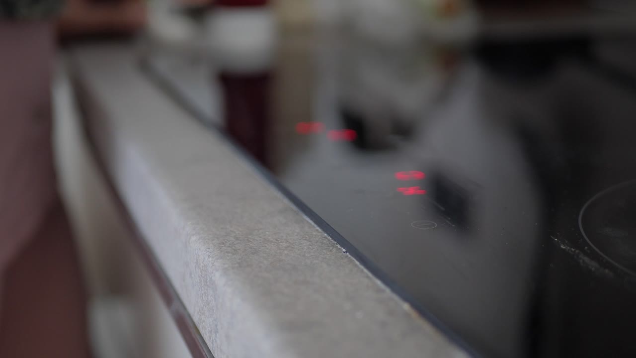 la mano tocando una estufa de tacto