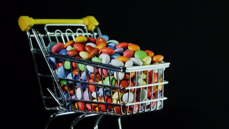 sweets in a shopping trolley on a black background 4k video