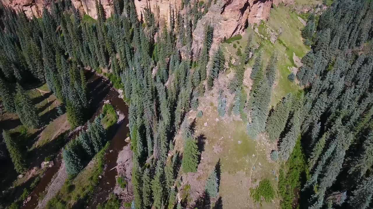 aéreo: incline lentamente hacia arriba para revelar un acantilado con un fondo montañoso