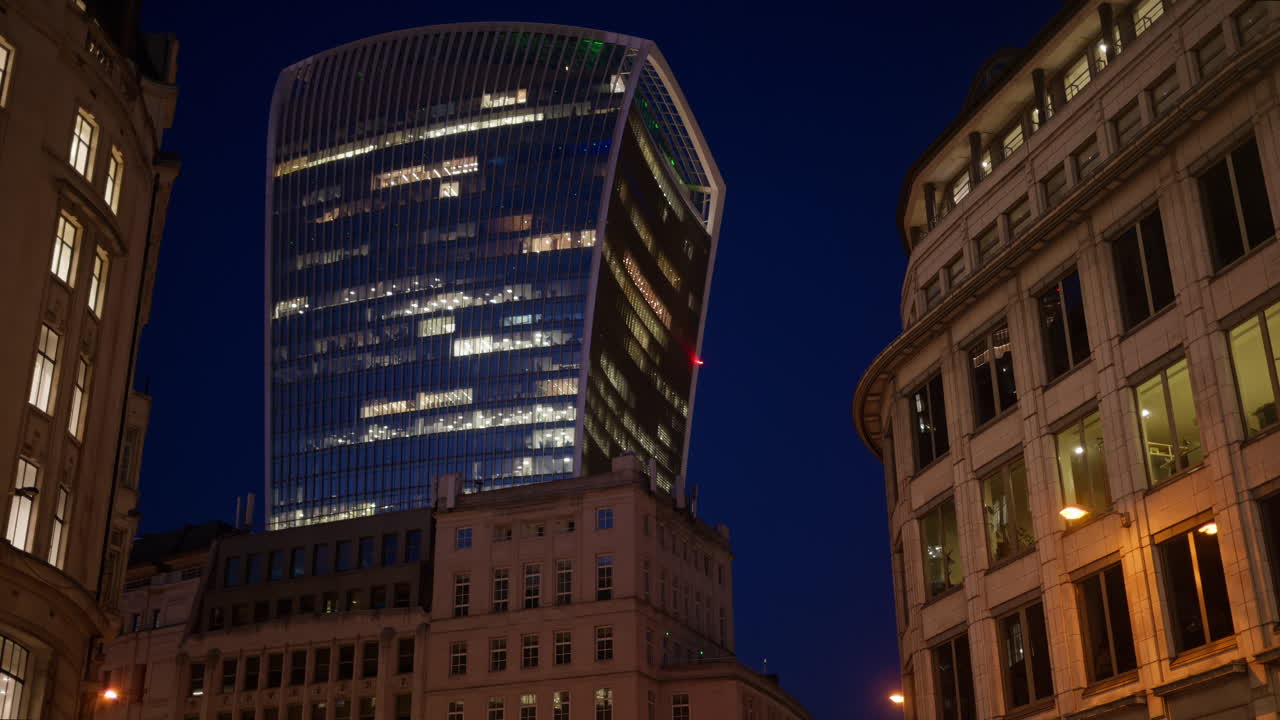 View of the Walkie-Talkie skyscraper standing tall above surrounding architecture in the evening blue hour, London, England