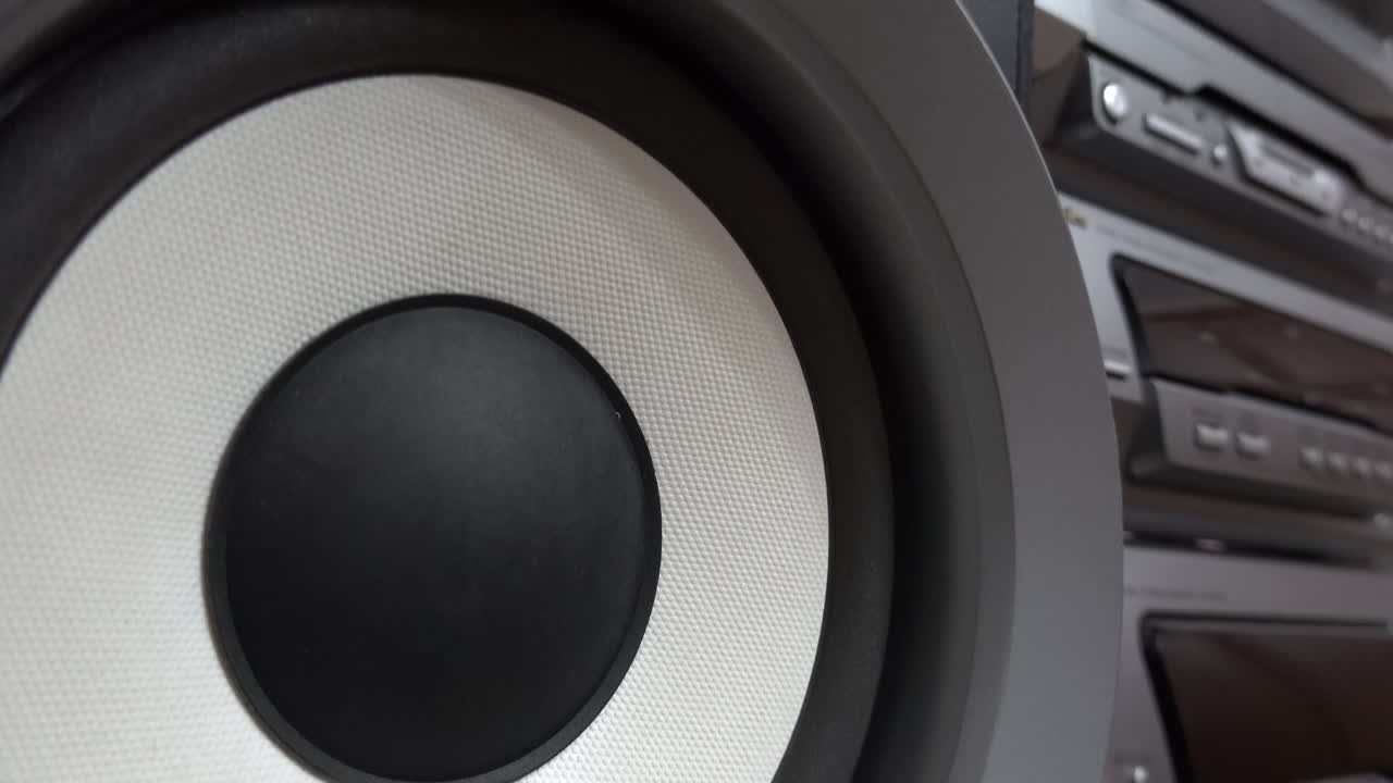 Close up of a speaker of a big, grey boombox