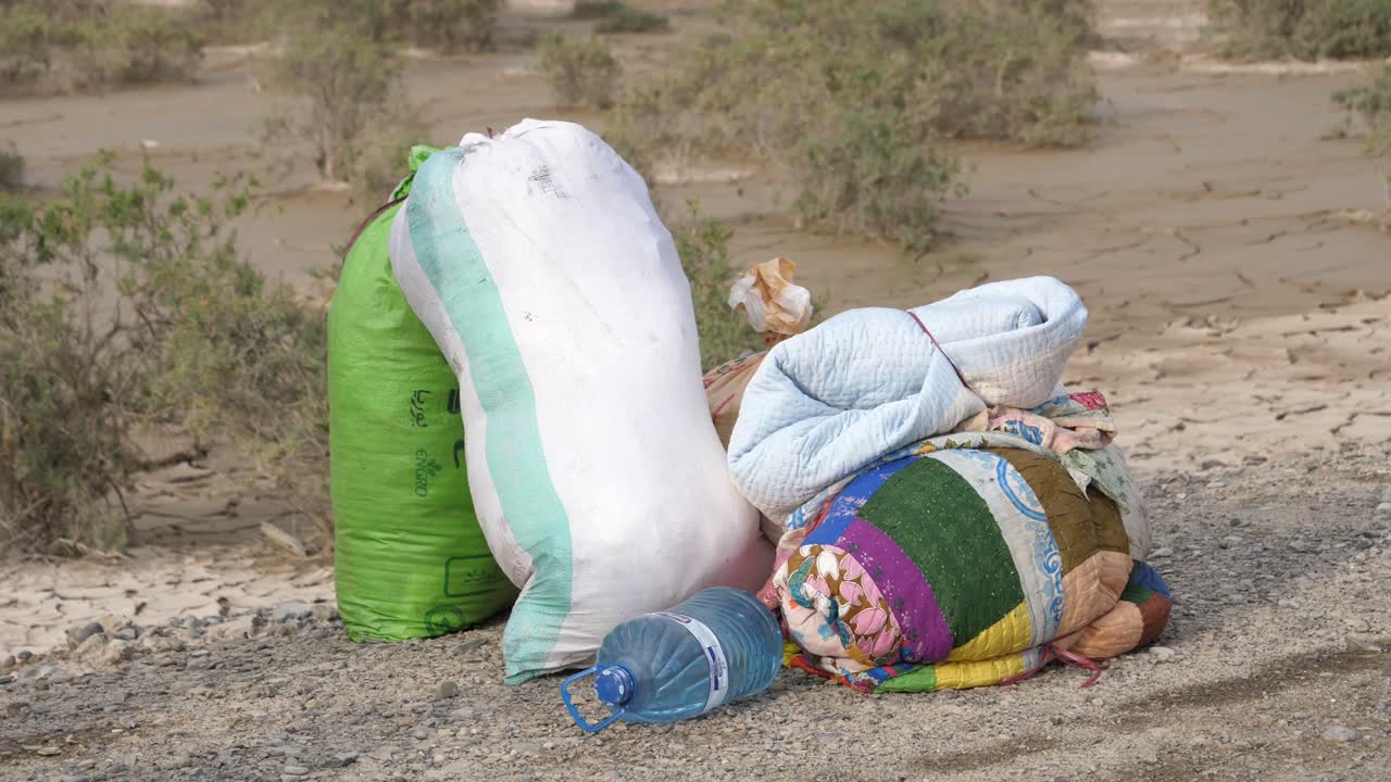 Sacchi di cibo e coperte a lato della strada in Baluchistan