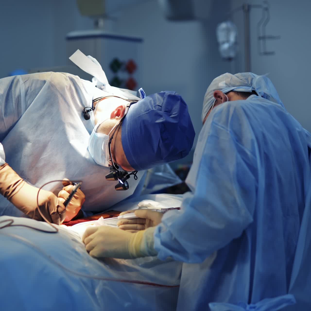 Group of surgeons in operating room with surgery equipment. Modern medical background. Selective focus