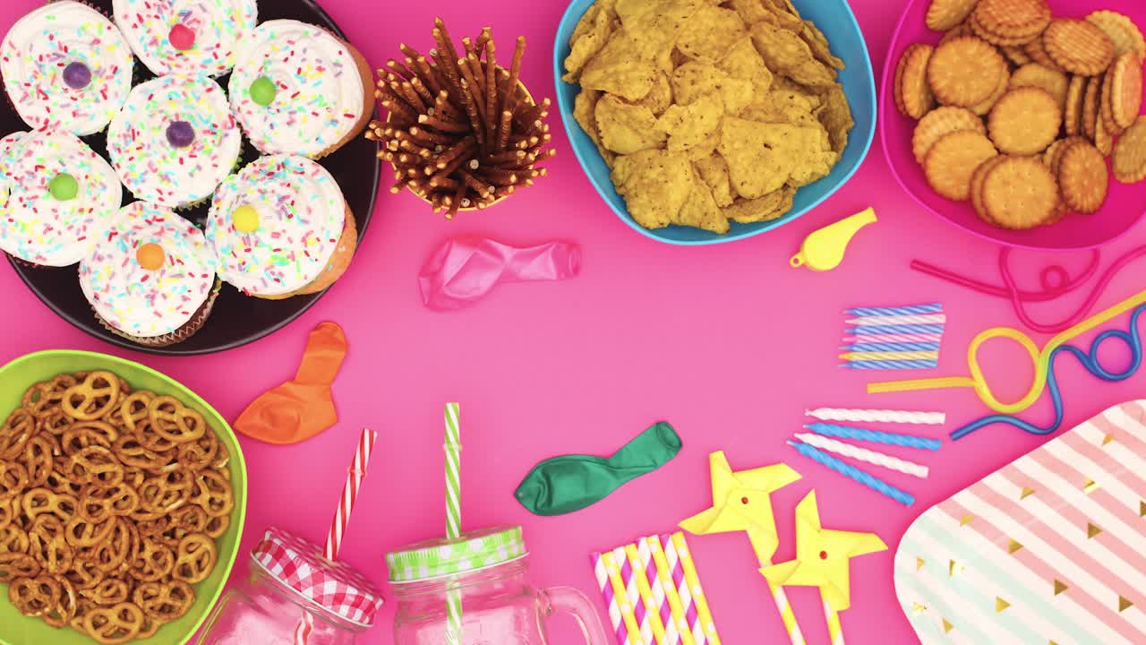 la decoración de la fiesta de cumpleaños, pasteles, comida, globos, pajitas, velas se mueven en la mesa rosa - stop motion