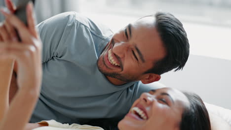 Happy-couple,-phone-and-laughing-on-bed-in-relax