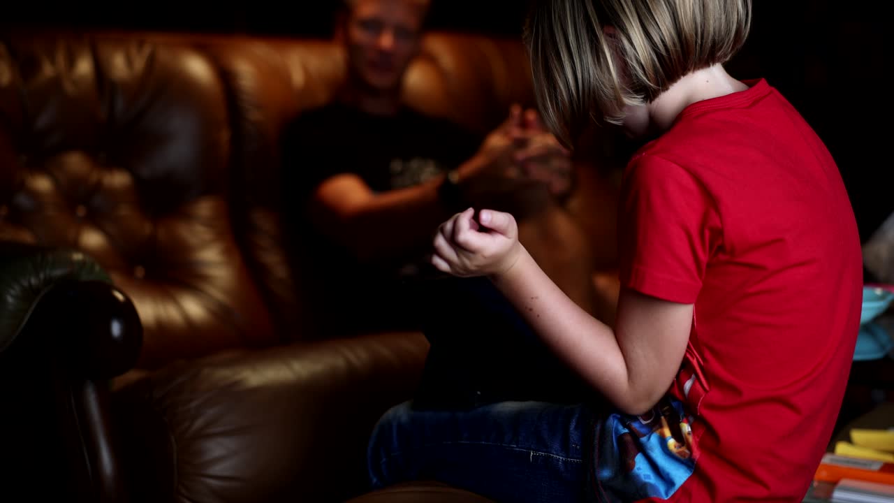 Un bambino che parla con un uomo su un divano