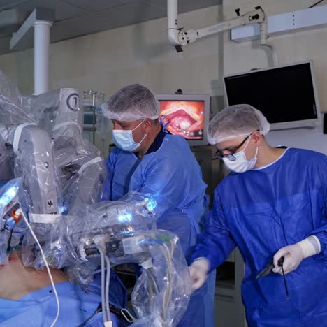 male surgeons stand by the robotic equipment. technological robot operates patient in the surgical room