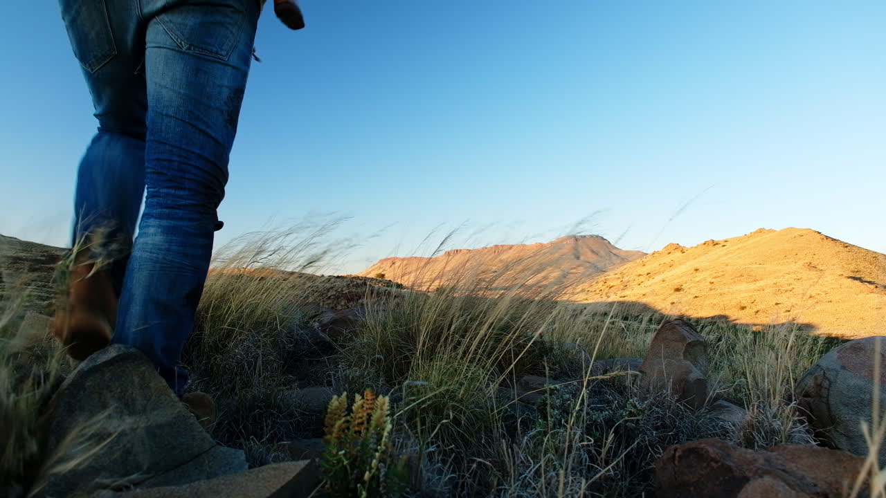cazador con un rifle sobre el hombro camina por la colina para mirar el vasto paisaje