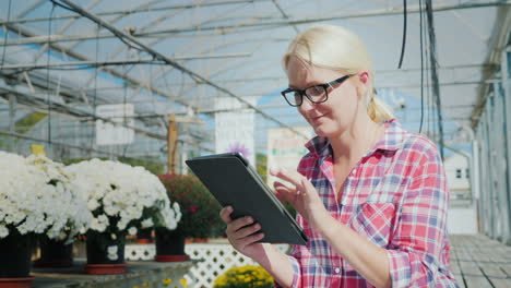 Frau-In-Einem-Gewächshaus-Mit-Einer-Tablette