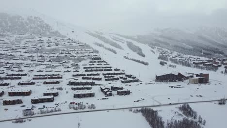 Temprano-En-La-Mañana-En-Myrkdalen-Noruega---Famoso-Destino-De-Esquí-Y-Pueblo-De-Montaña---Telesilla-En-Funcionamiento-Y-Automóviles-Que-Comienzan-A-Llegar---Descripción-Aérea-De-Myrkdalen-Nevado