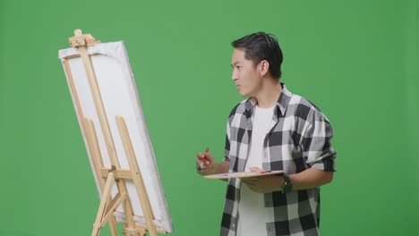 man painting on an easel
